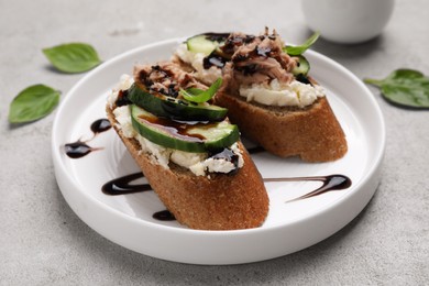 Photo of Delicious bruschettas with balsamic vinegar and toppings on light textured table, closeup