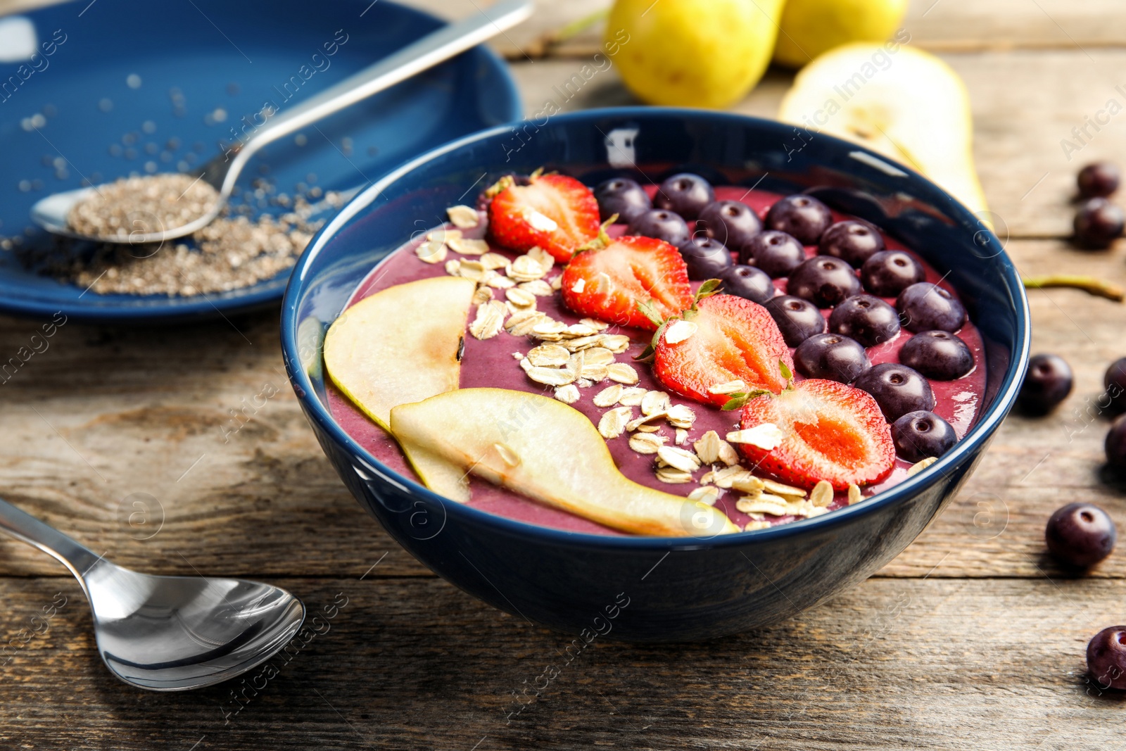 Photo of Bowl with tasty acai smoothie on wooden table