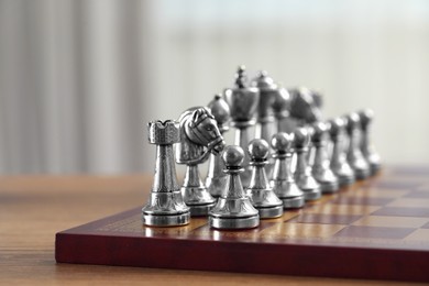 Photo of Chess board with pieces on wooden table, closeup