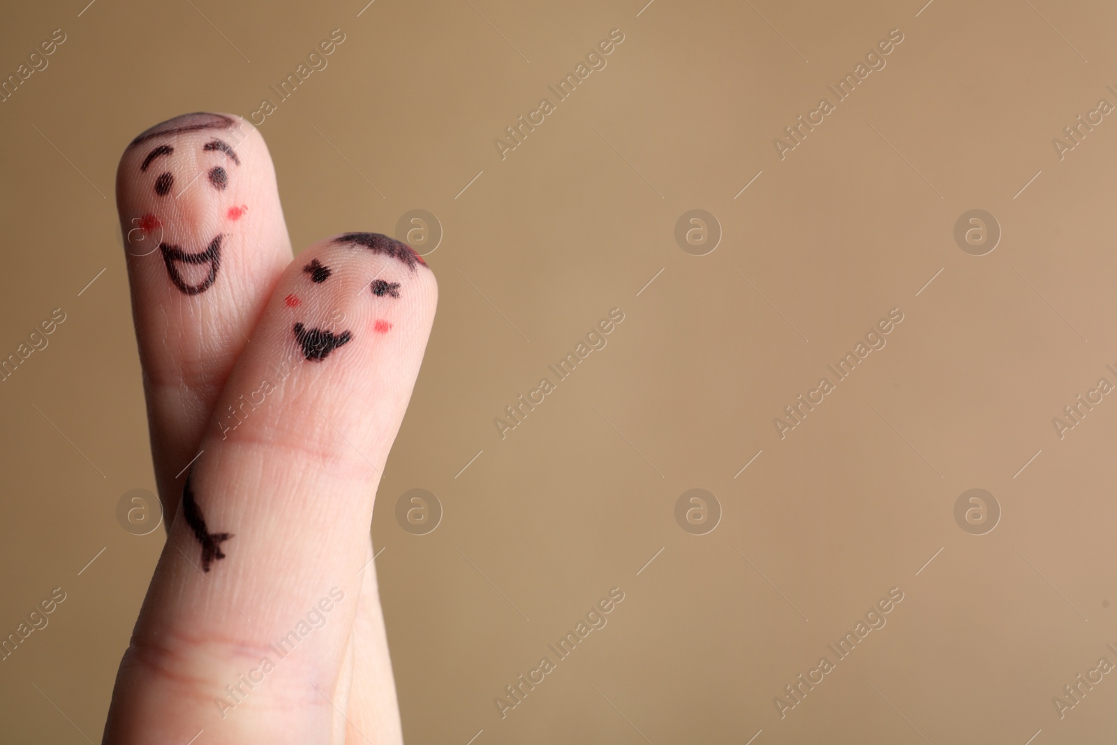 Photo of Two fingers with drawings of happy faces on brown background, space for text. Spending time together