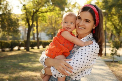 Photo of Young mother with her cute baby in park on sunny day