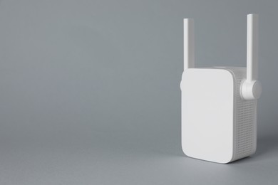 New modern Wi-Fi repeater on light gray background, space for text