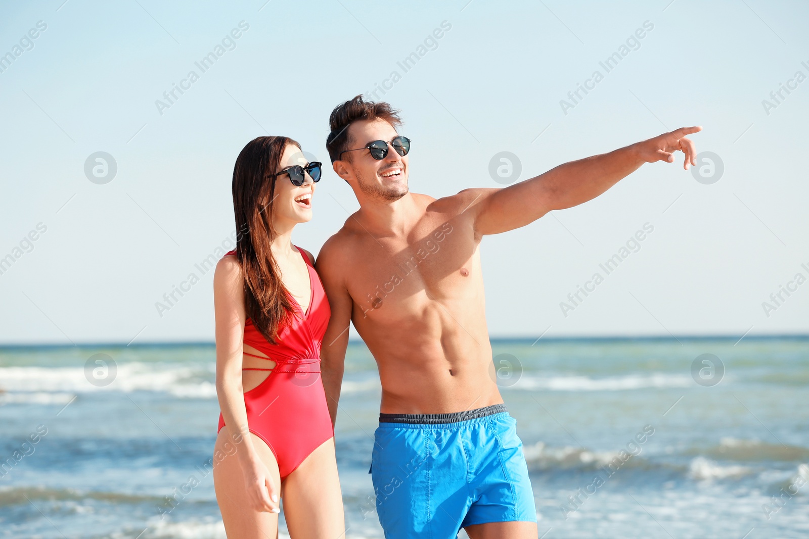 Photo of Happy young couple walking together on beach