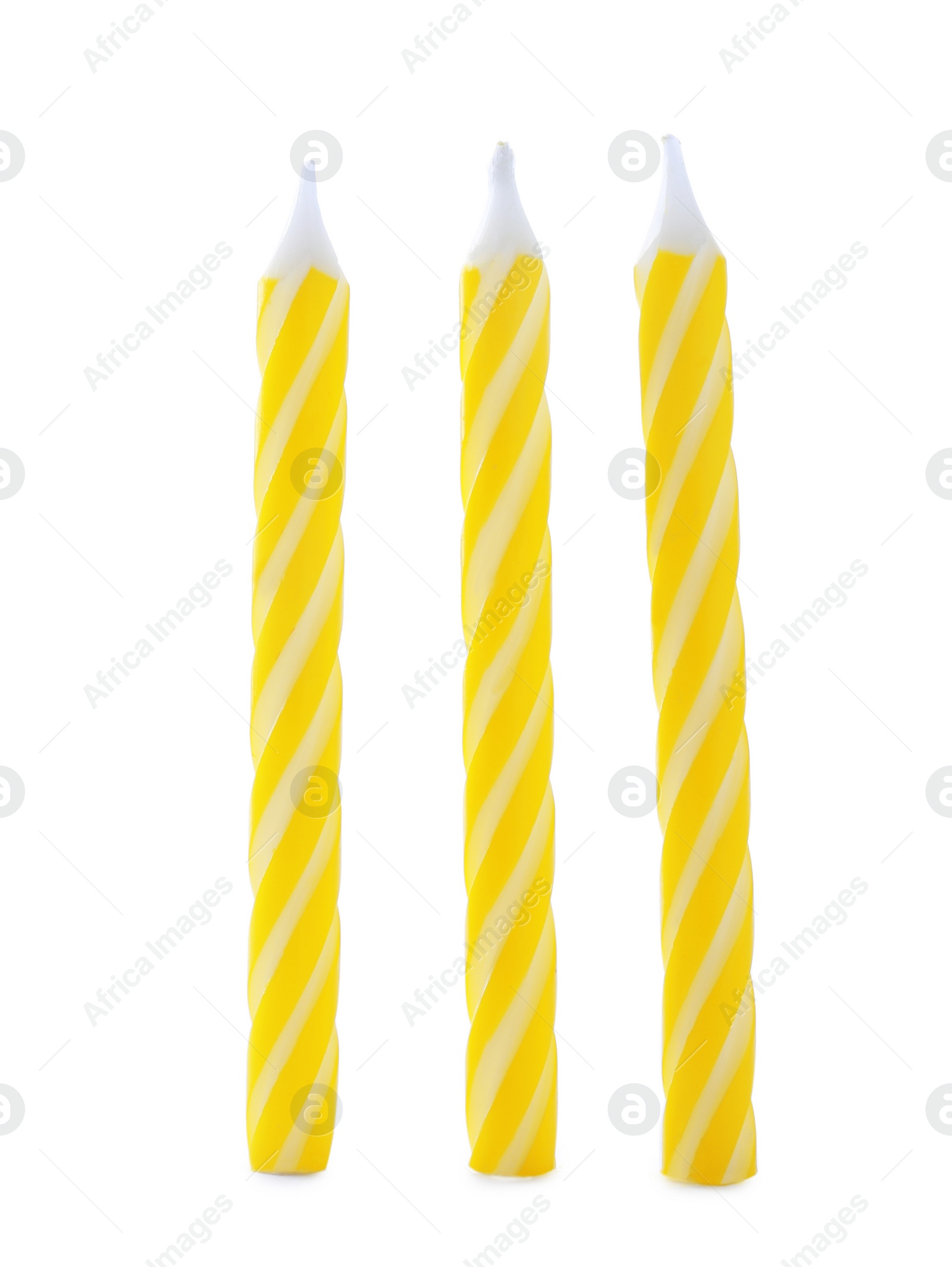 Photo of Yellow striped birthday candles isolated on white