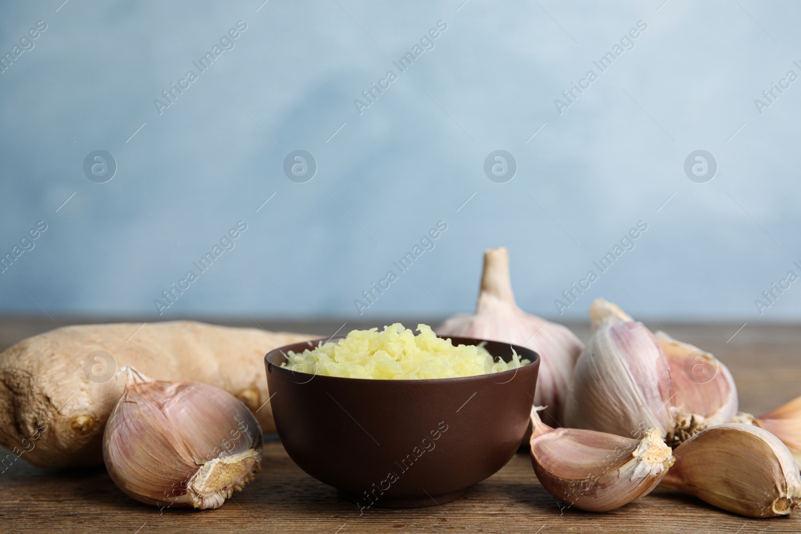 Photo of Fresh garlic and ginger on wooden table, space for text. Natural cold remedies