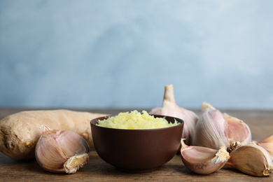 Photo of Fresh garlic and ginger on wooden table, space for text. Natural cold remedies