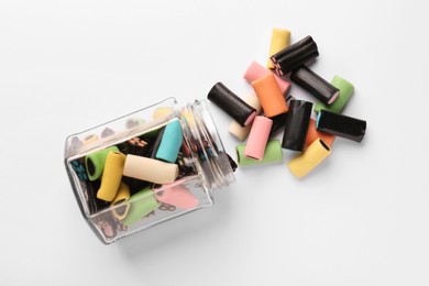 Photo of Glass jar of tasty liquorice candies on light background, top view