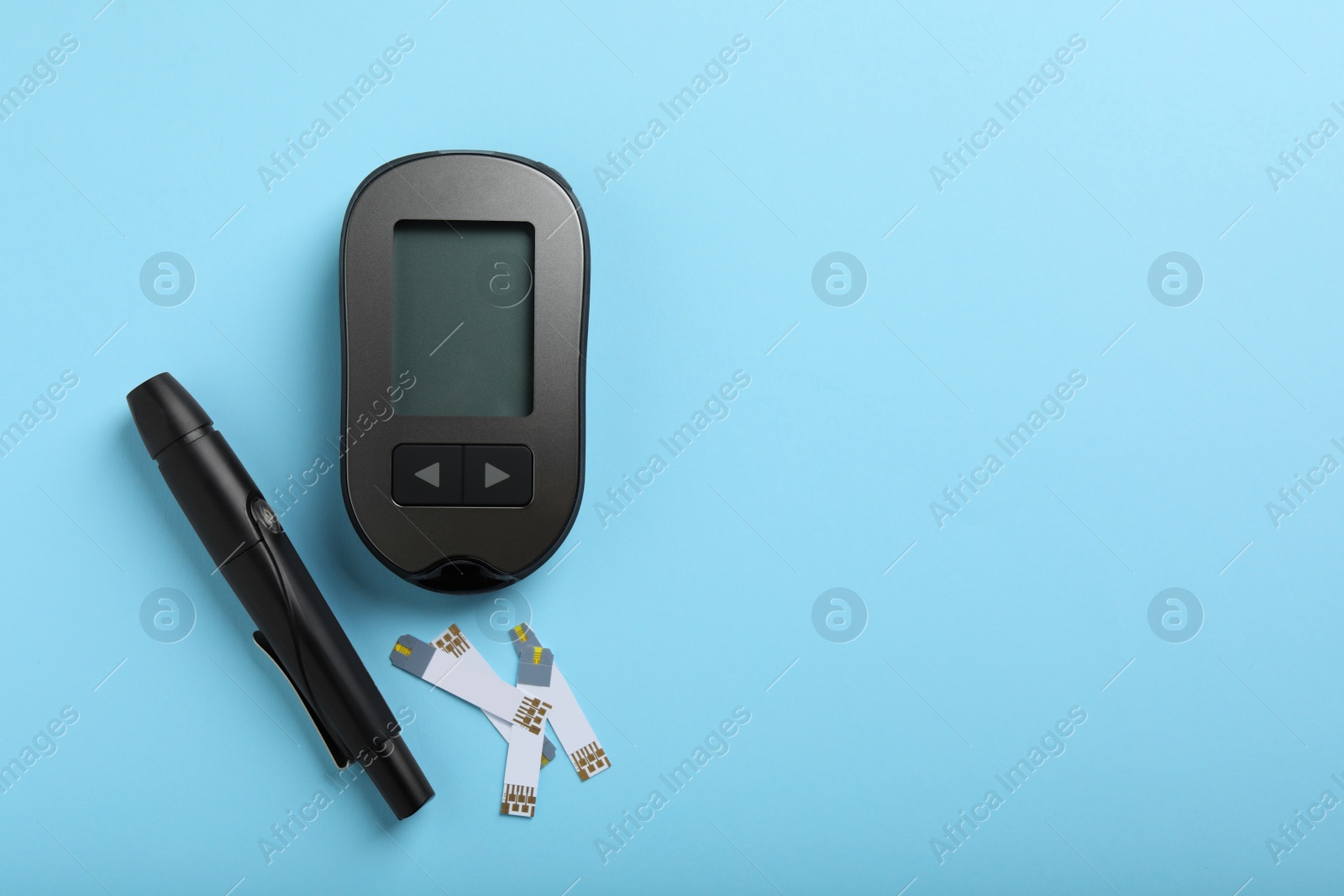 Photo of Digital glucometer, lancet pen and test strips on light blue background, flat lay with space for text. Diabetes control