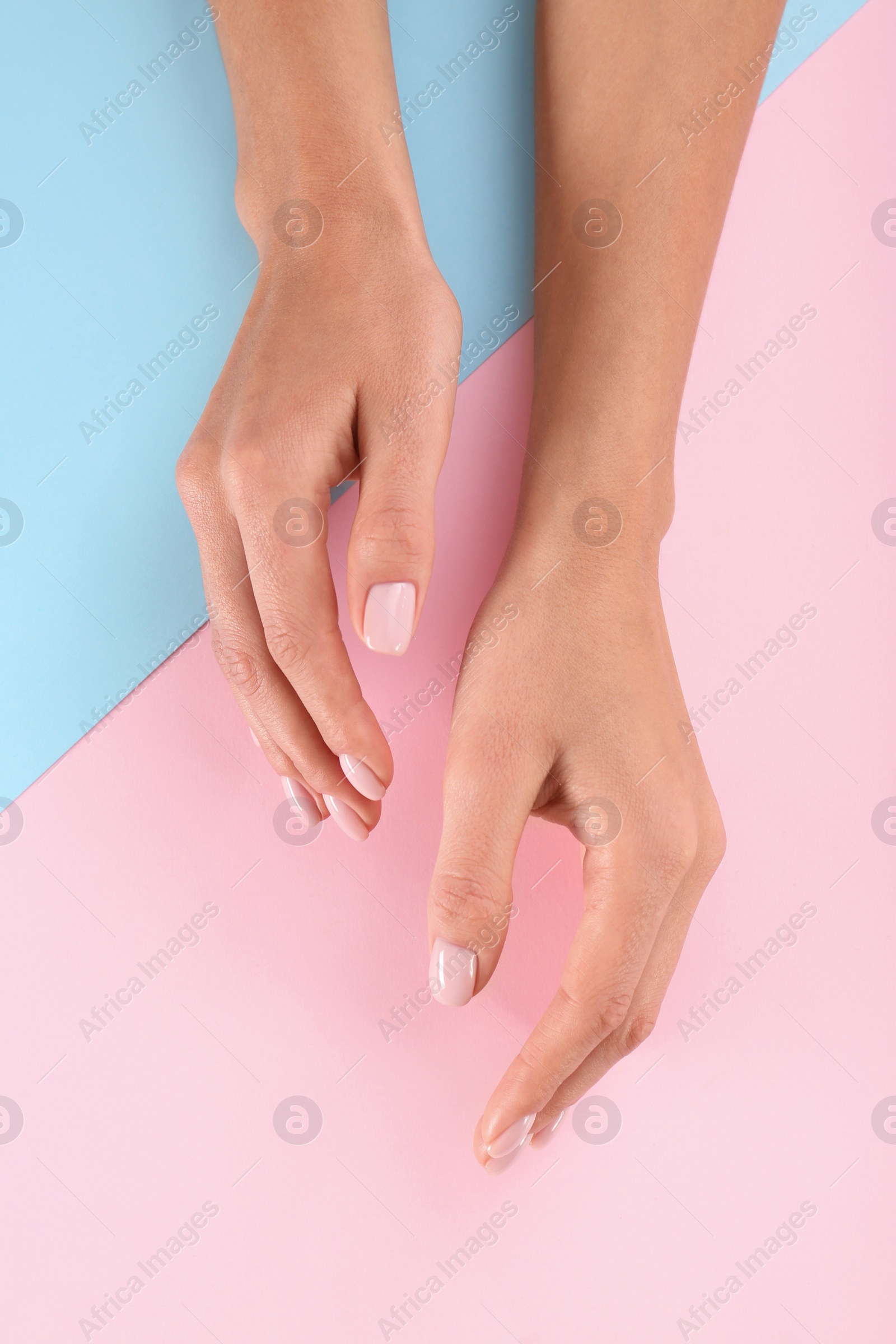 Photo of Closeup view of woman with beautiful hands on color background. Spa treatment