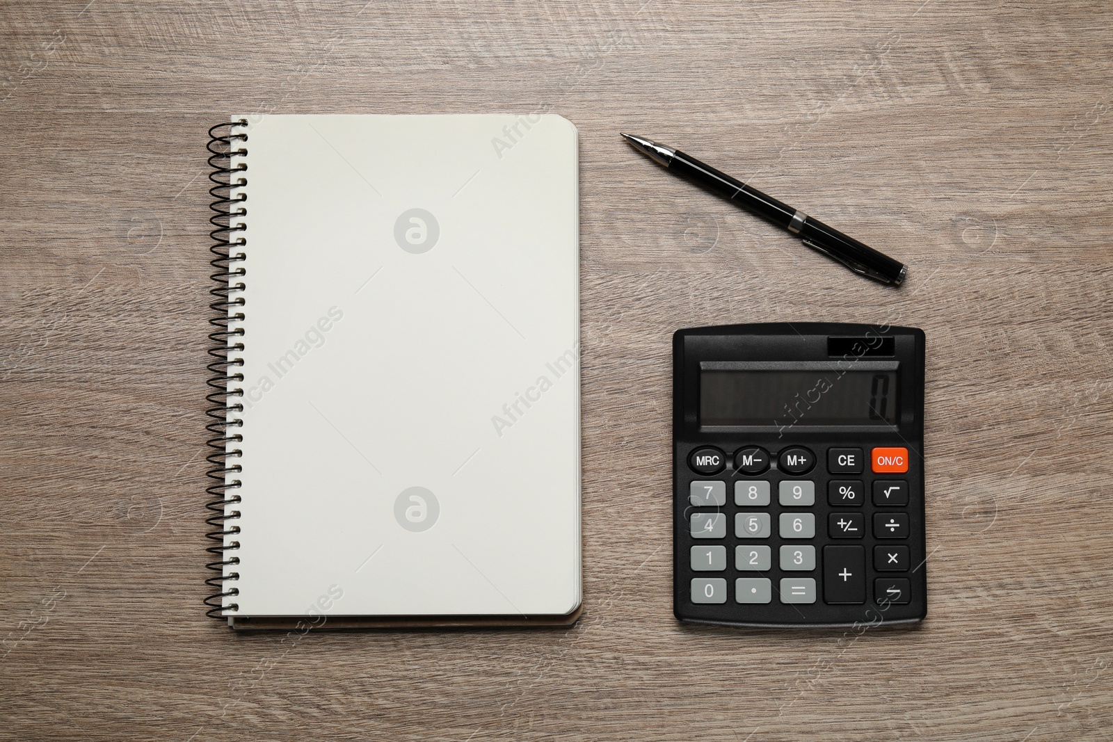 Photo of Calculator and office stationery on wooden table, flat lay. Space for text