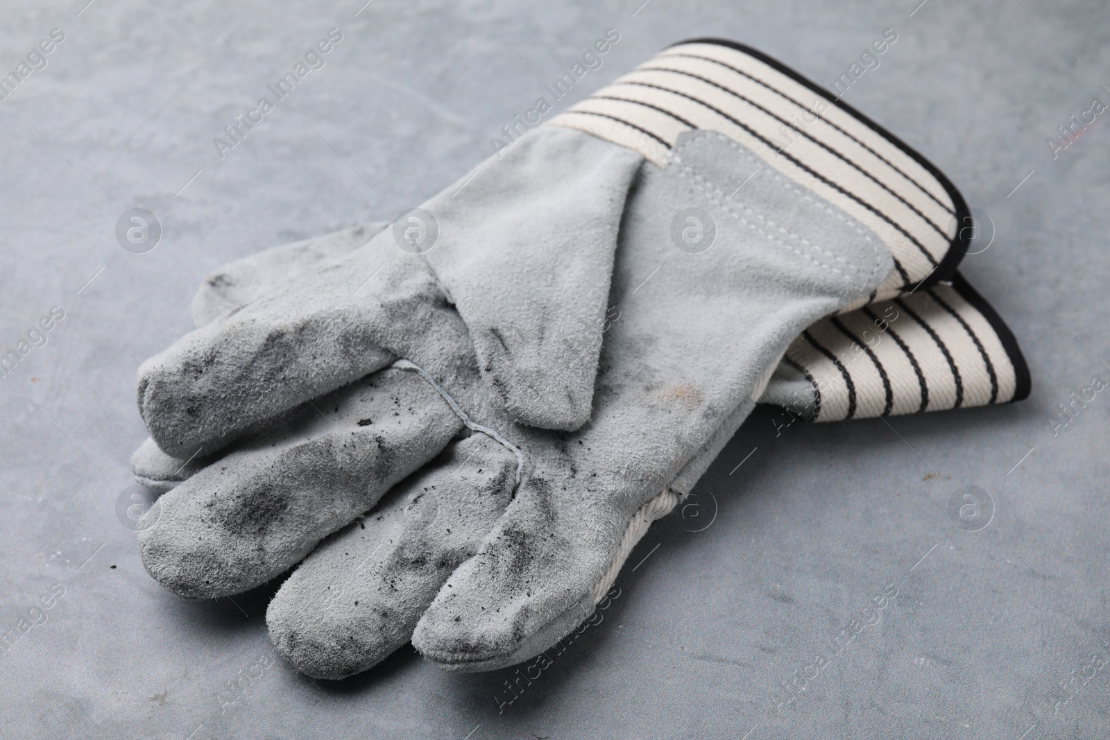 Photo of Pair of color gardening gloves on light grey table, closeup