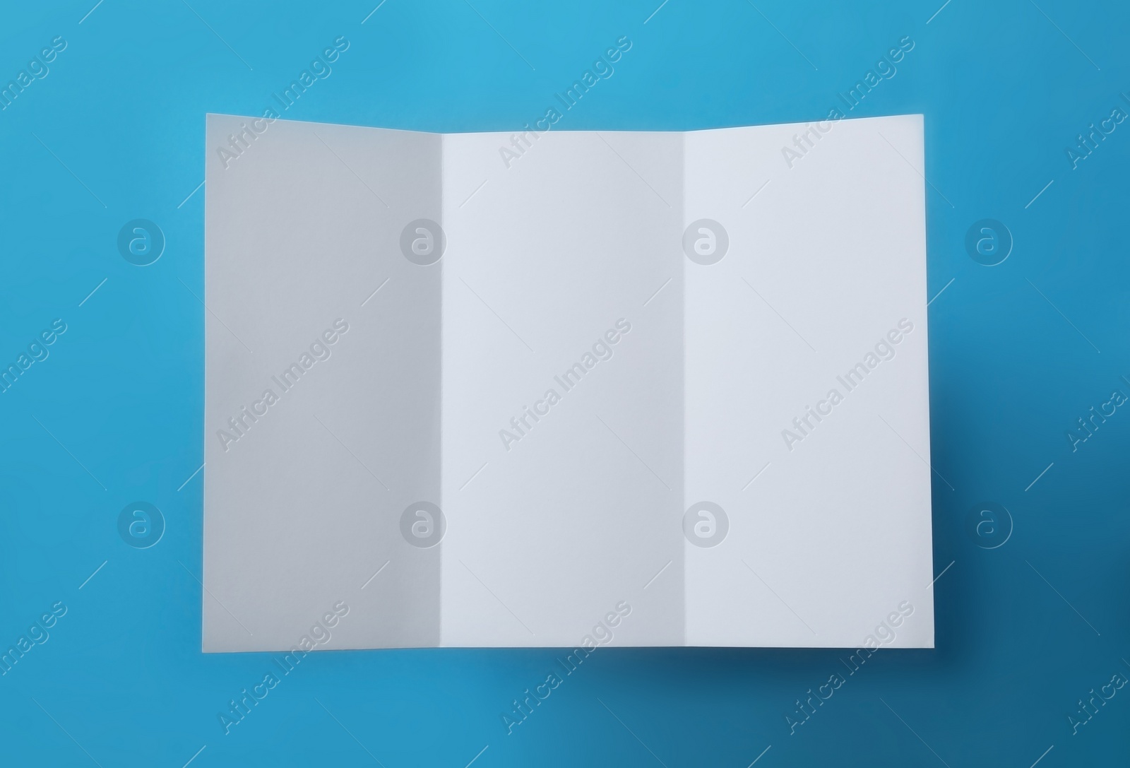 Photo of Empty flyer on blue background, top view. Mockup for design