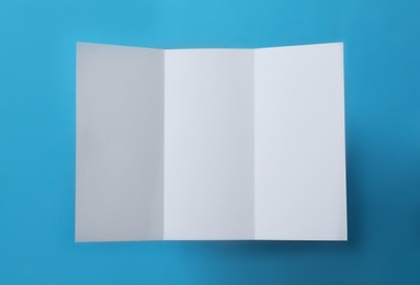 Photo of Empty flyer on blue background, top view. Mockup for design