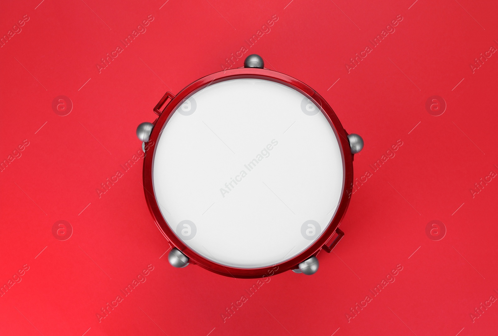 Photo of Drum on red background, top view. Percussion musical instrument