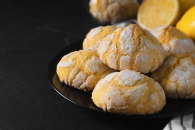 Photo of Plate with delicious lemon cookies on black table, closeup