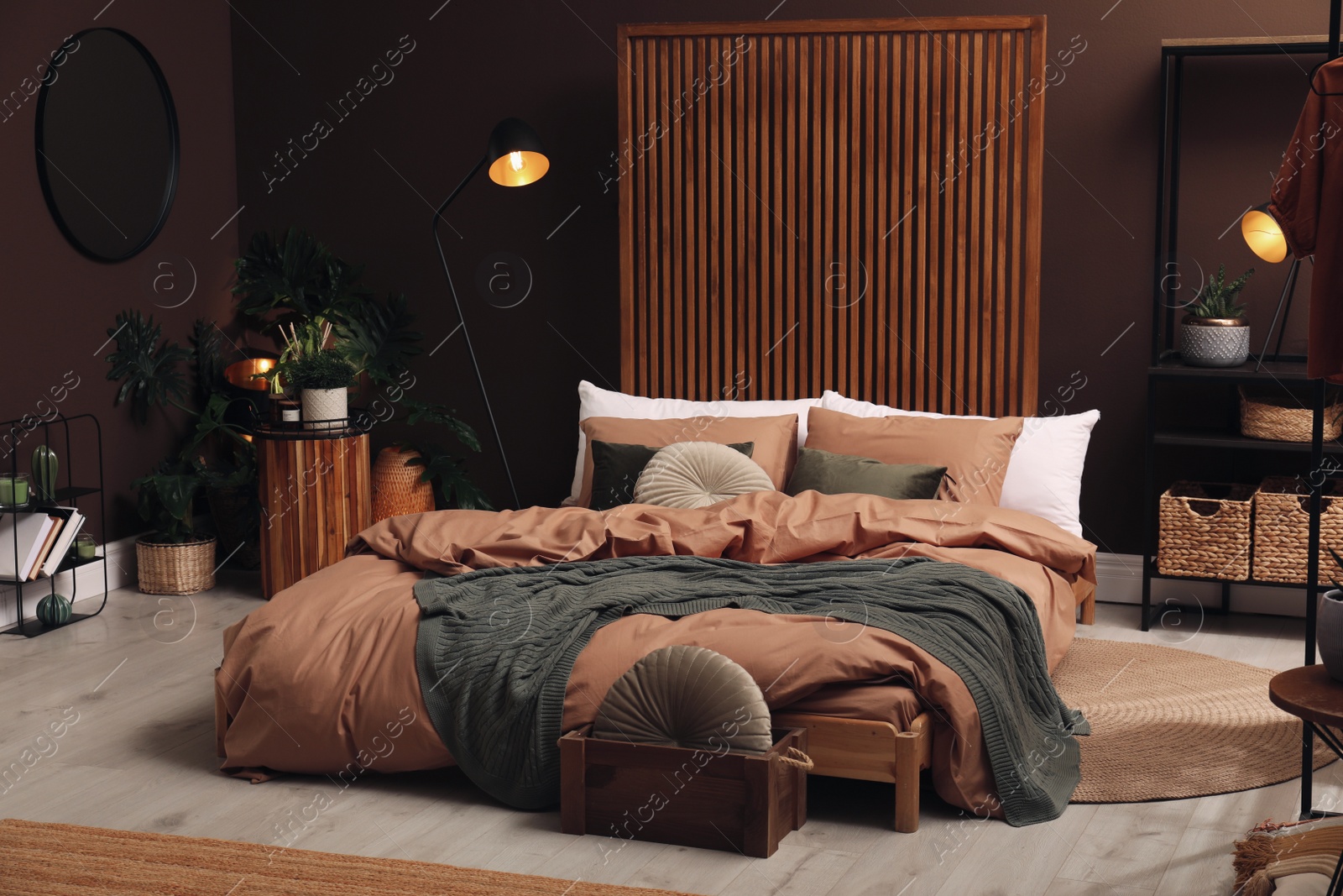 Photo of Stylish room interior with large bed near brown wall