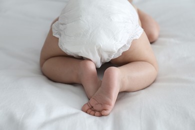 Cute little baby in diaper on bed