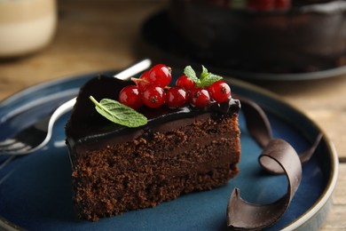 Photo of Piece of tasty homemade chocolate cake with berries and mint on plate, closeup