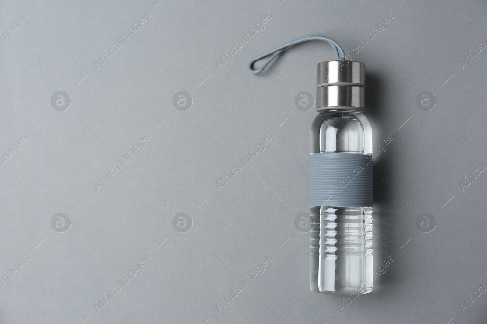 Photo of Sport bottle with space for text on color background, top view