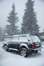 Photo of Car covered with snow outdoors on winter day