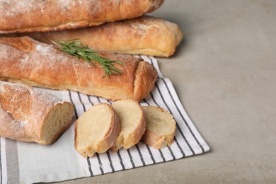 Fresh crispy baguettes on grey table, closeup. Space for text