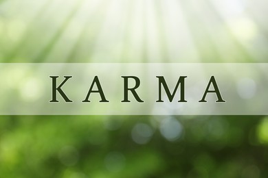 Image of Word KARMA on blurred green background, bokeh effect 