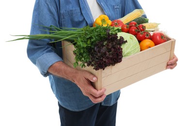 Photo of Harvesting season. Farmer holding wooden crate with vegetables on white background, closeup