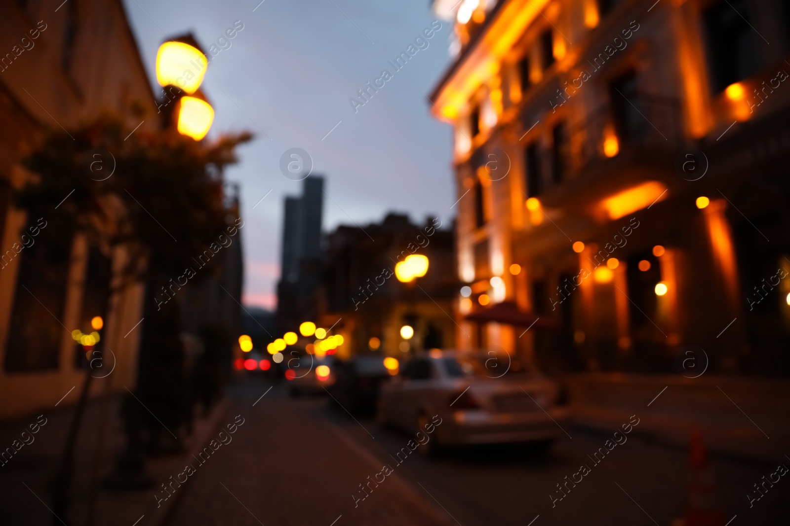 Photo of Blurred view of beautiful cityscape with glowing streetlights and illuminated building in evening