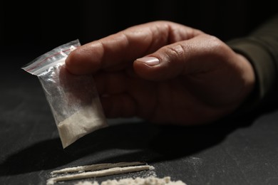 Drug addiction. Man with cocaine at grey table, closeup