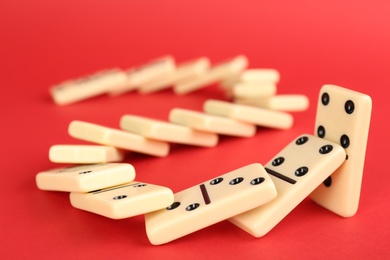 Photo of White domino tiles falling on red background