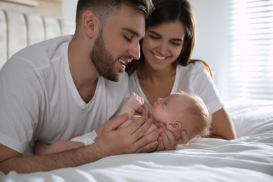 Photo of Happy couple with their newborn baby at home