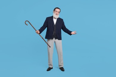 Photo of Senior man with walking cane on light blue background