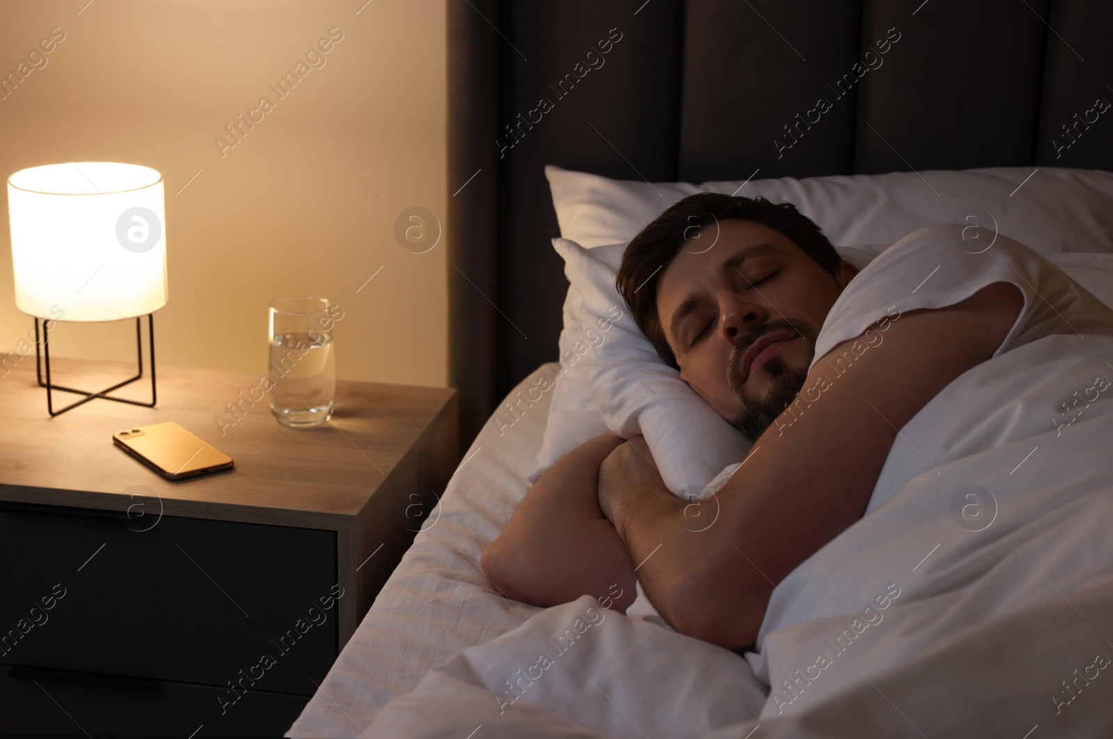 Photo of Handsome man sleeping in bed at night