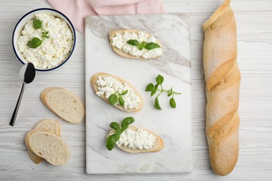 Photo of Bread with cottage cheese and basil on white wooden table, flat lay