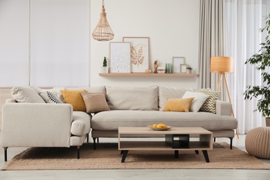 Photo of Stylish living room interior with comfortable grey sofa and coffee table