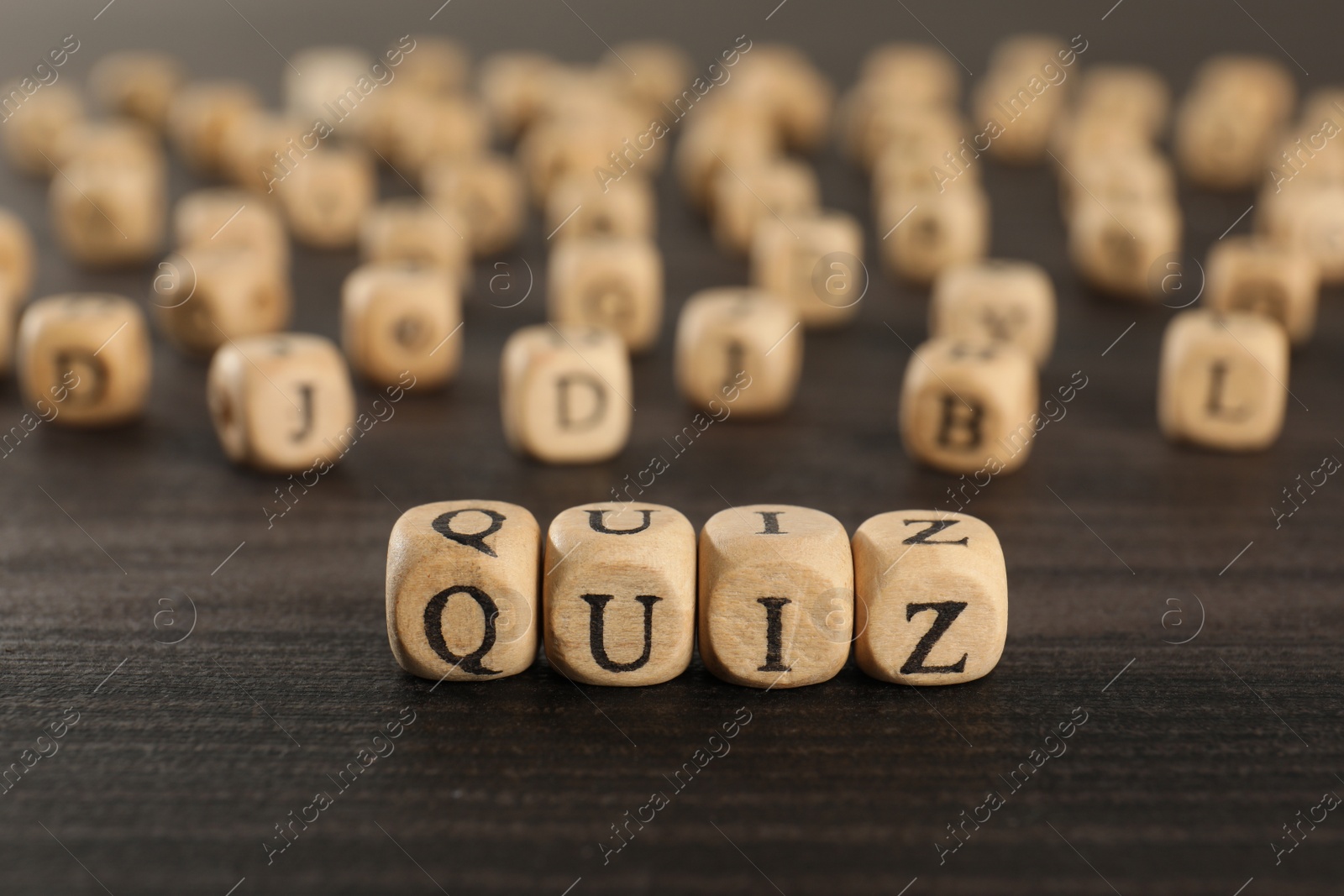 Photo of Cubes with word Quiz on wooden table. Space for text