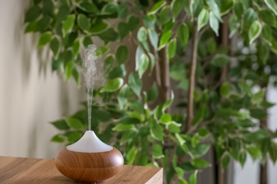 Aroma oil diffuser lamp on table indoors