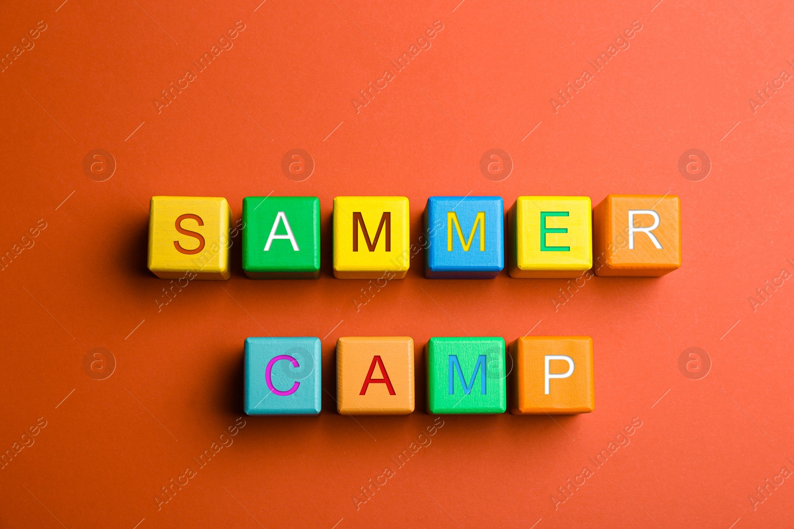 Photo of Colorful wooden cubes with phrase SUMMER CAMP on red background, flat lay