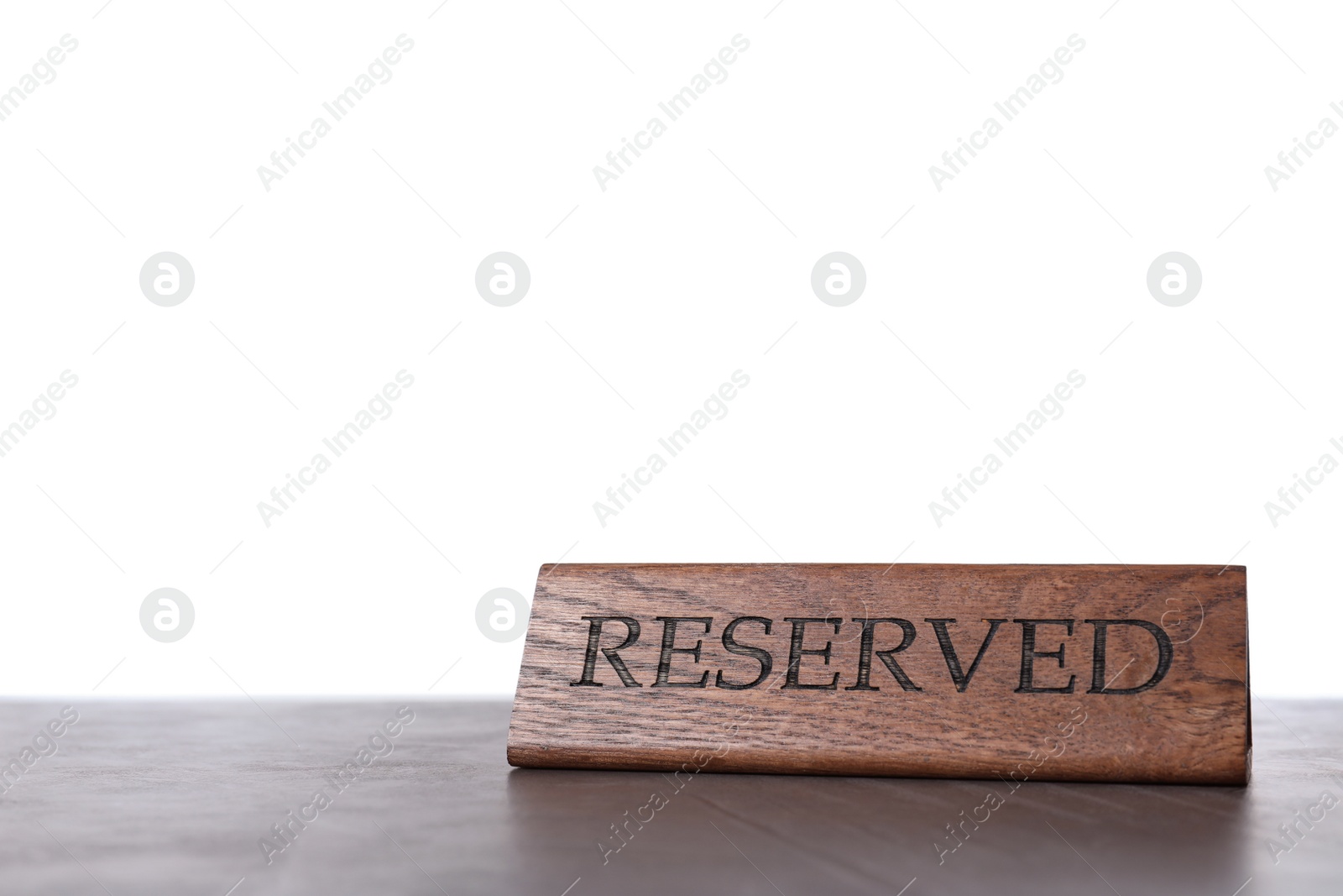 Photo of Elegant wooden sign Reserved on grey table against white background, space for text