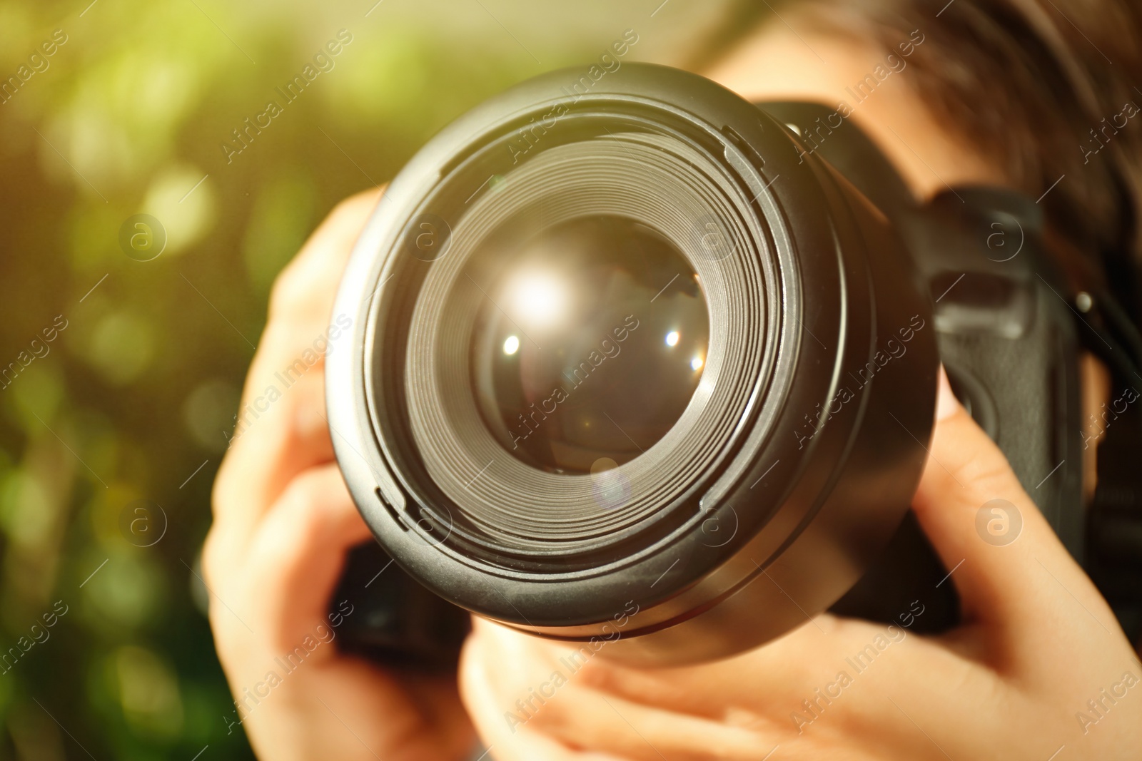 Image of Photographer with professional camera on blurred background, closeup