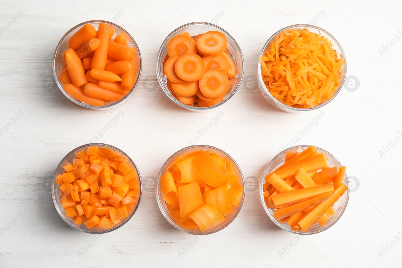 Photo of Flat lay composition with cut carrots on wooden background