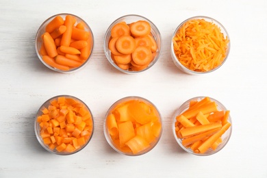 Photo of Flat lay composition with cut carrots on wooden background