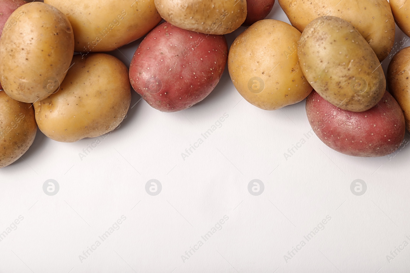 Photo of Fresh organic potatoes and space for text on white background, top view