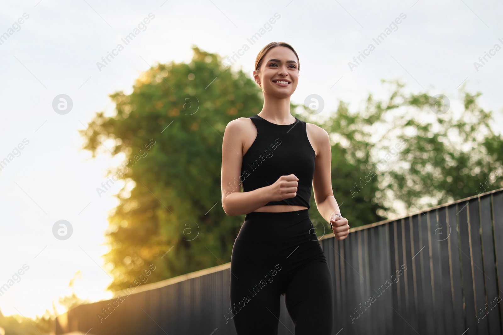 Photo of Attractive sporty woman in fitness clothes jogging outdoors