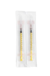 Photo of Packed disposable syringes with needles on white background, top view