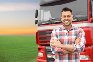 Photo of Portrait of driver at modern truck outdoors. Space for text