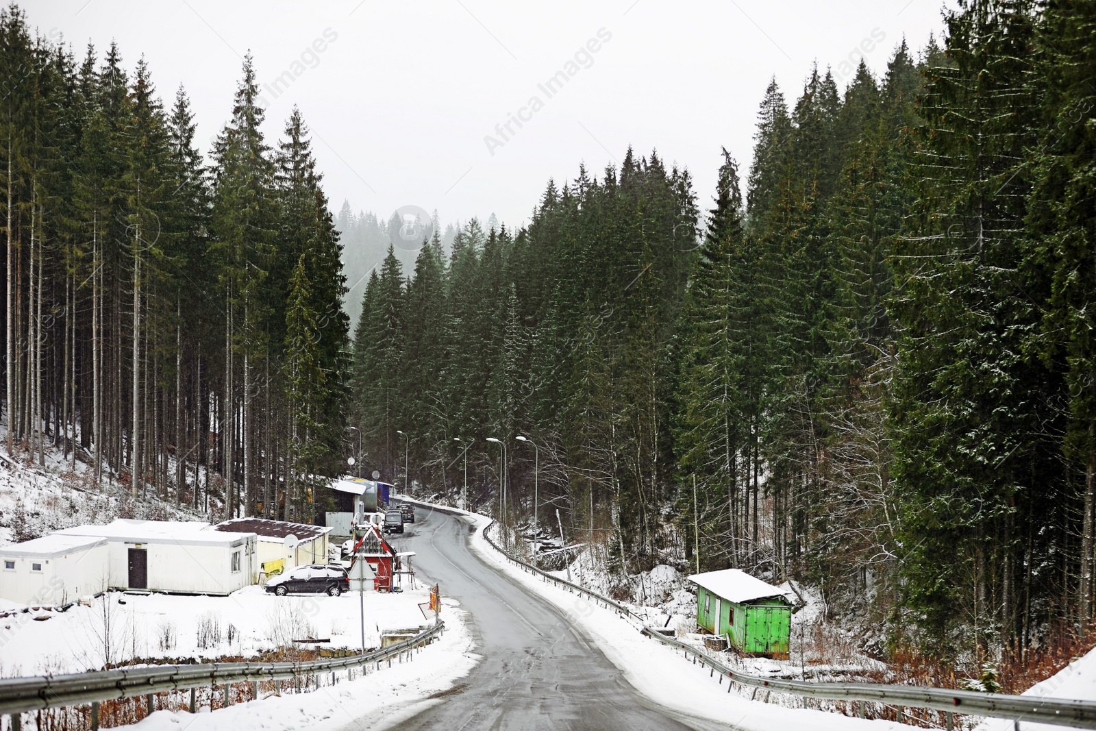 Photo of Beautiful landscape with conifer forest and road on snowy winter day