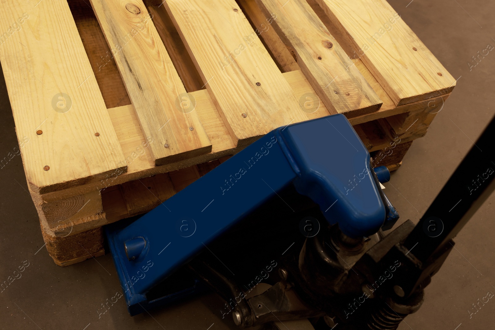 Image of Modern manual forklift with wooden pallets in warehouse, closeup