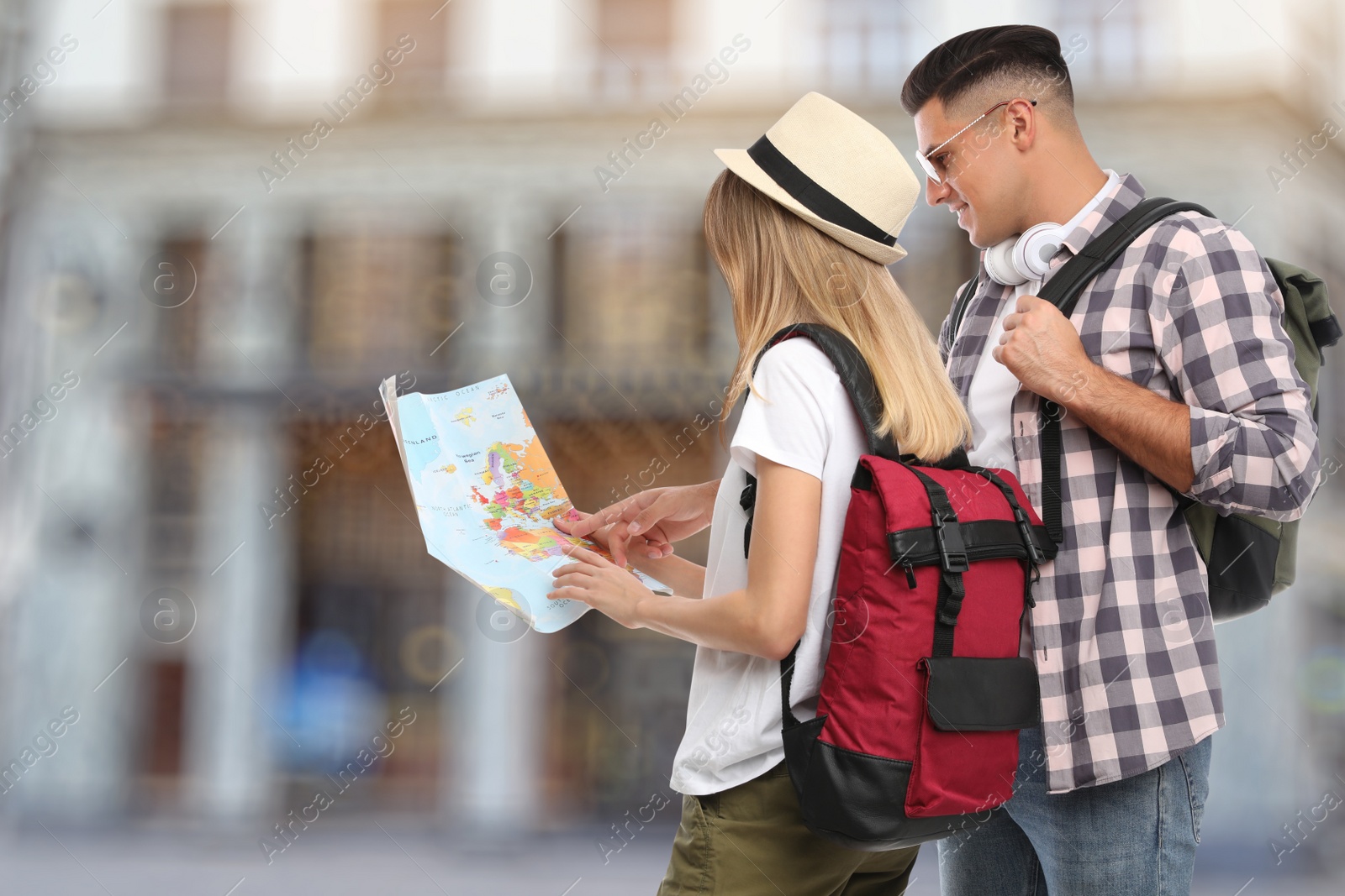 Image of Couple of travelers with map in foreign city. Summer vacation trip