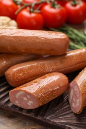 Delicious vegan sausages and tomatoes on wooden table, closeup